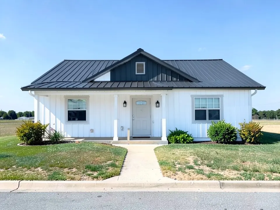 The same barndominium with white siding and trim and a dark charcoal metal roof; porch kept, front gable dark