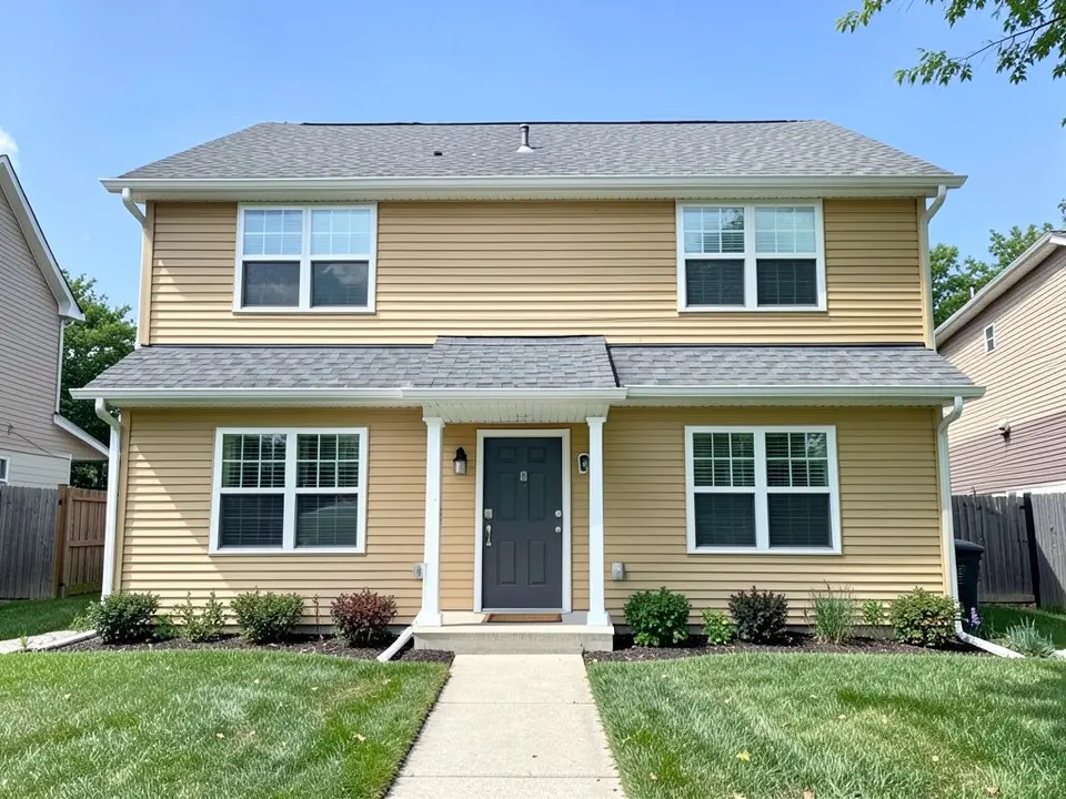 AI-drawn generic stand-in of a two-story house with yellow-tan horizontal siding, white window trim, a dark gray front door under a small porch and a medium gray shingle roof