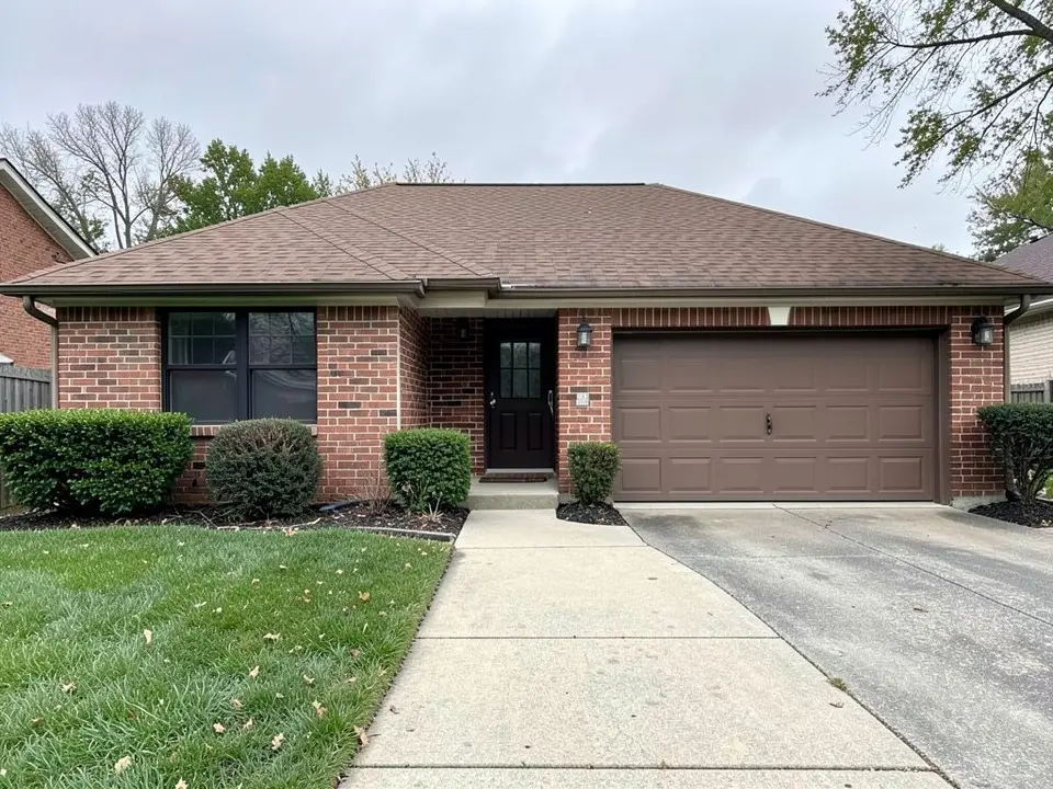 AI-drawn generic stand-in of a one-story red brick ranch house with a brown shingle roof, a brown garage door and dark window frames