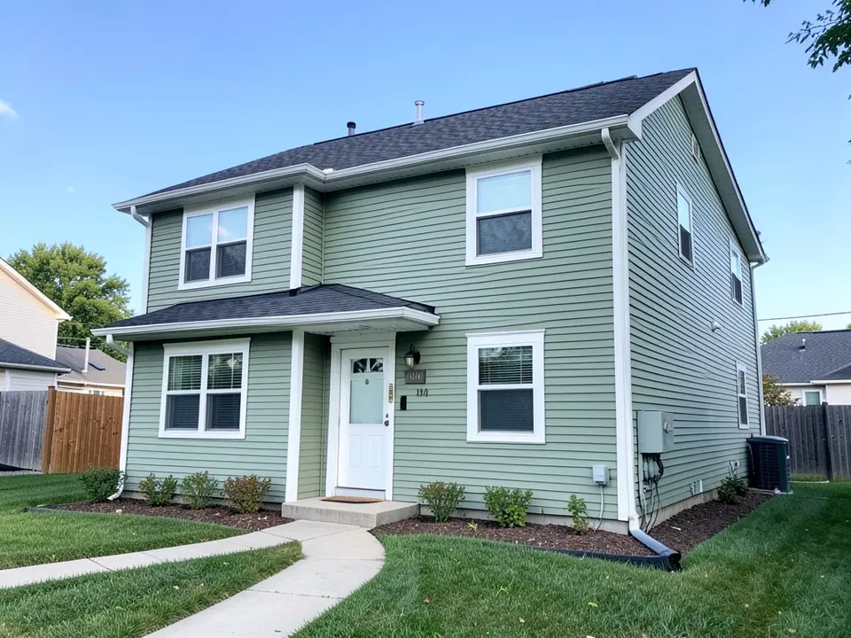 AI-drawn generic stand-in of a sage green horizontal-sided two-story house with white window trim and white corner trim, a white front door and a dark gray roof