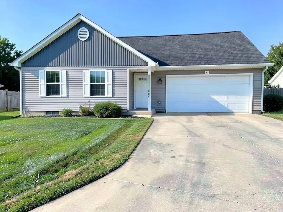 The same house with the gable wall now dark slate gray with vertical ribs and the round vent kept; the light gray siding below, the white garage door and the roof look the same