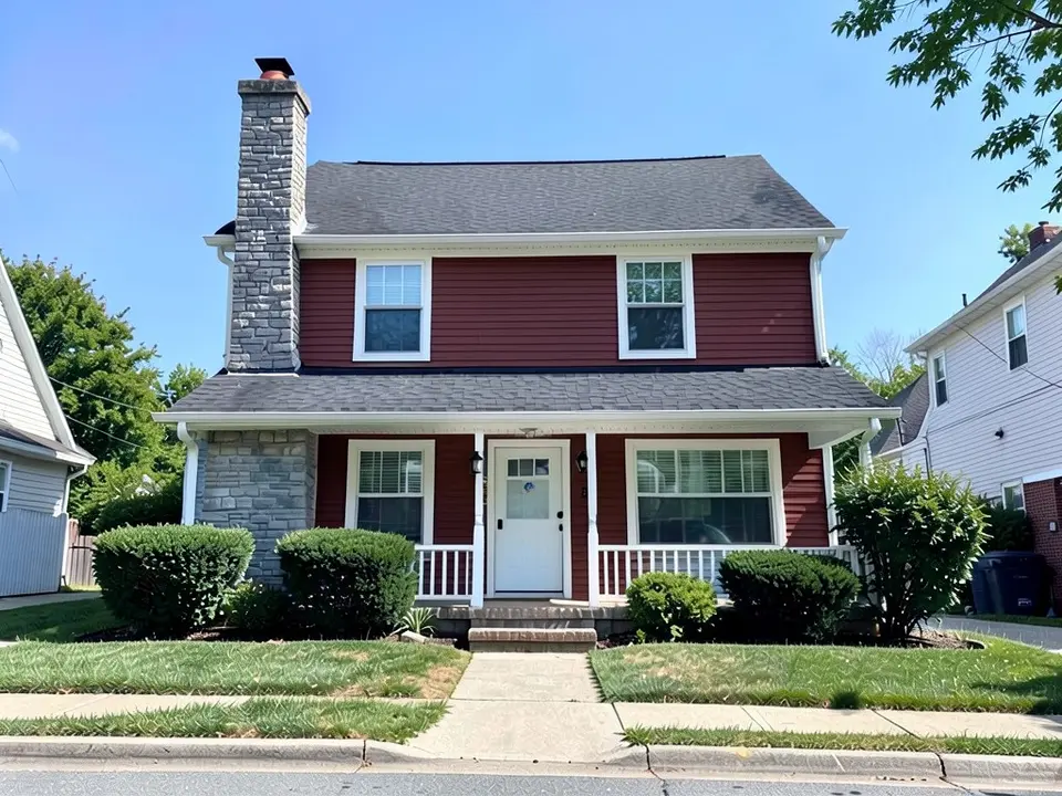 The same house with deep muted red siding; white trim, stone chimney and roof kept