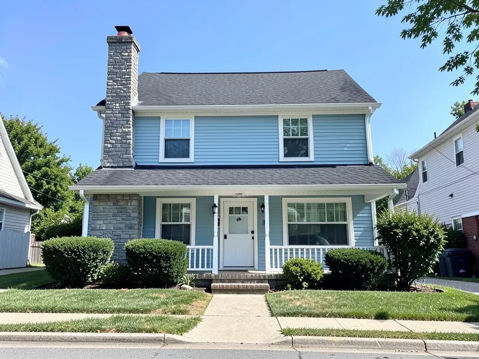 AI-drawn generic stand-in of a two-story house with light blue siding, white trim, a gray stone chimney and stone porch wall on one side and a dark shingle roof